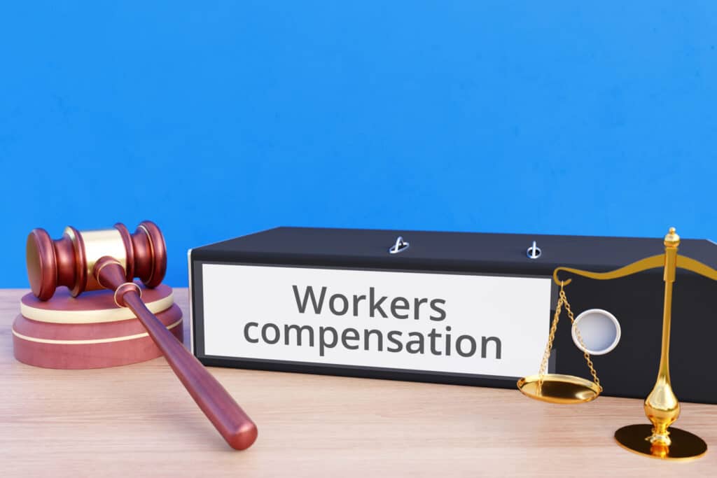 Workers compensation. File Folder with labeling, gavel and libra. Law, judgement, lawyer