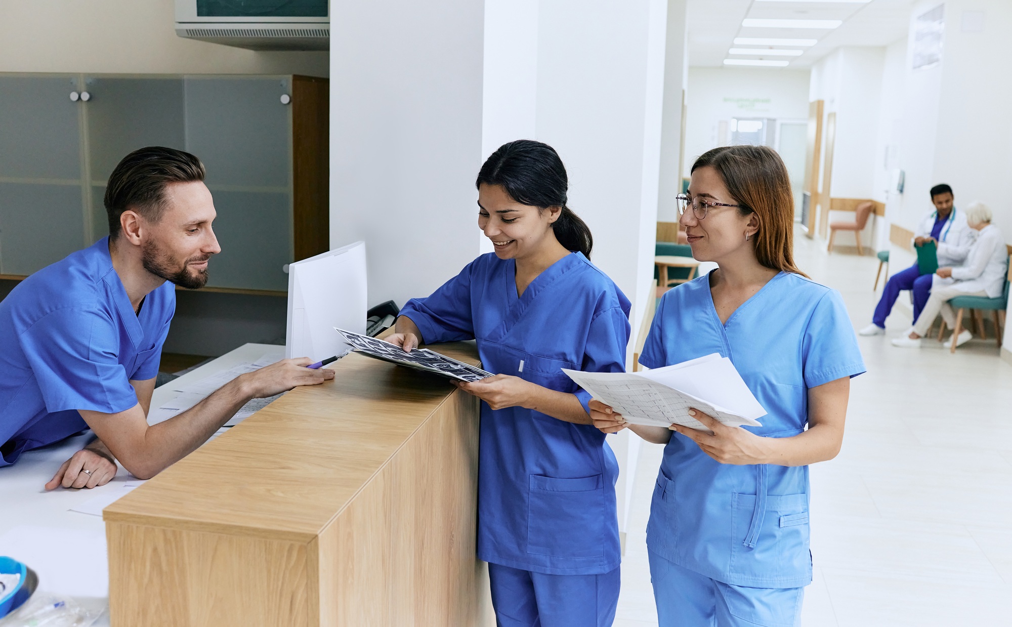 Medical employees. Medical assistant on duty talking with female nurses while working day in