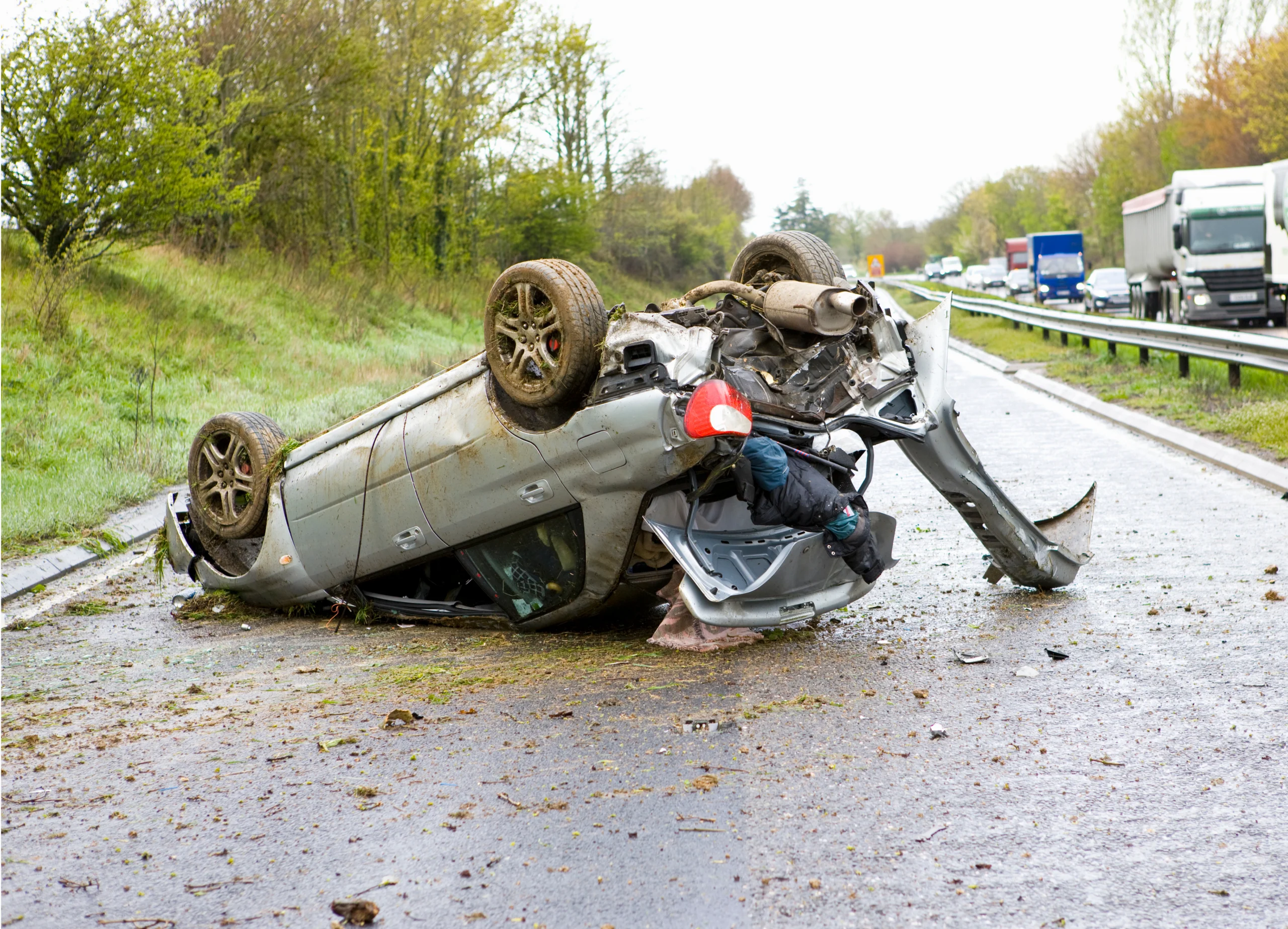 car after a crash lying upside down on a motorway