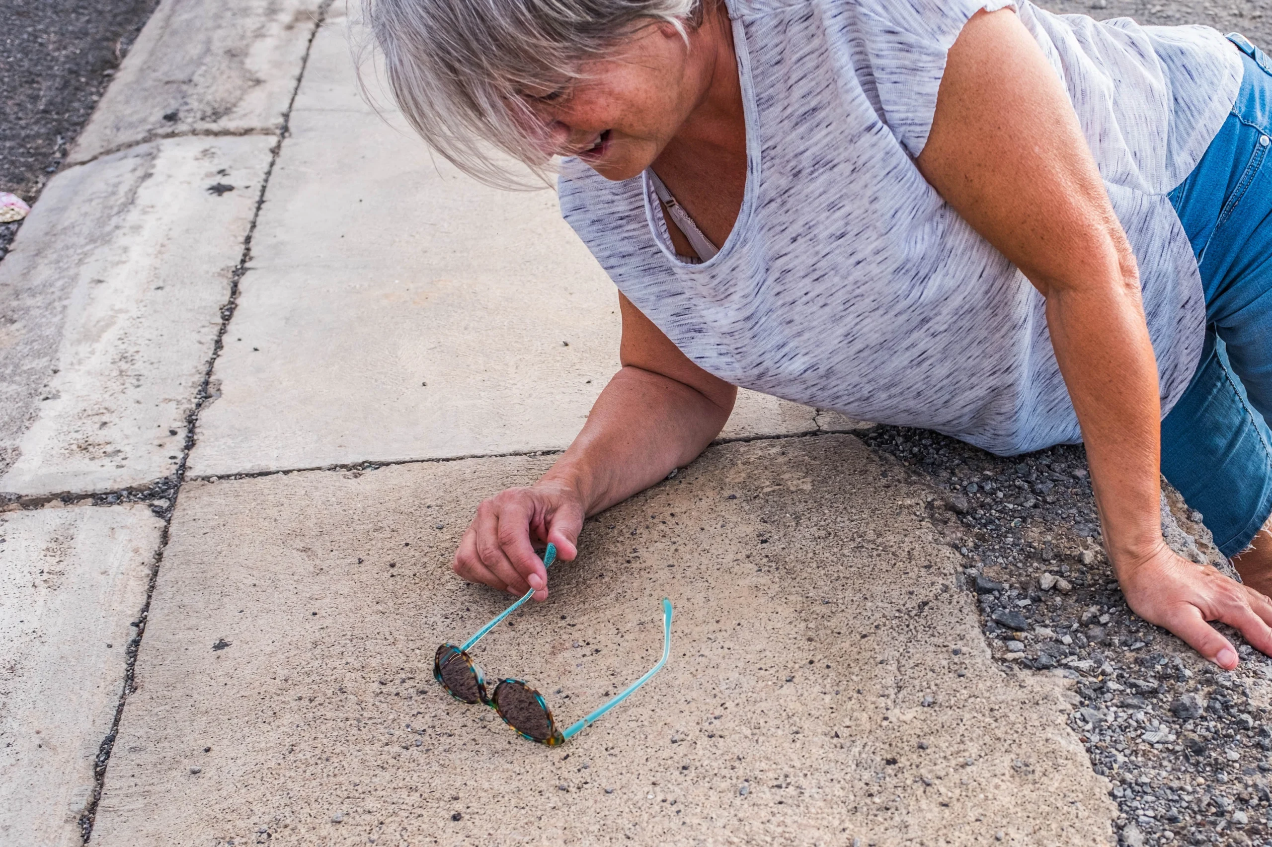 mature woman or senior fallen on the sidewalk